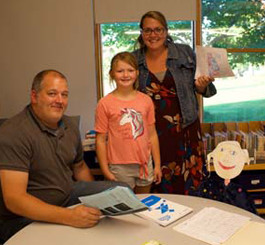 Student with her parents in a classroom